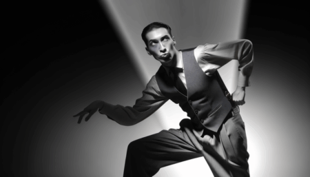alt_text: Walton Goggins in a dynamic pose, embodying film noir and western themes with dramatic lighting.